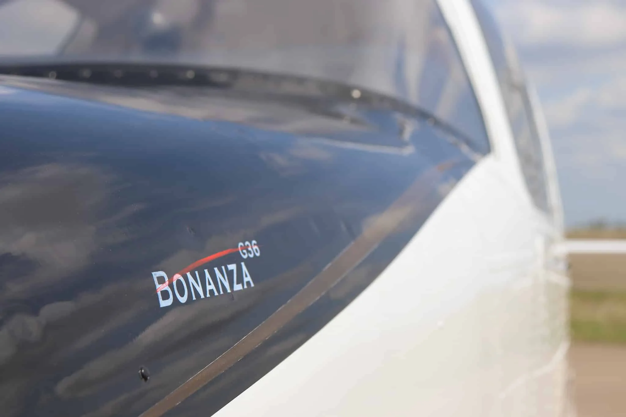 A close-up of the 'BONANZA G36' text on the black cowl of the aircraft.