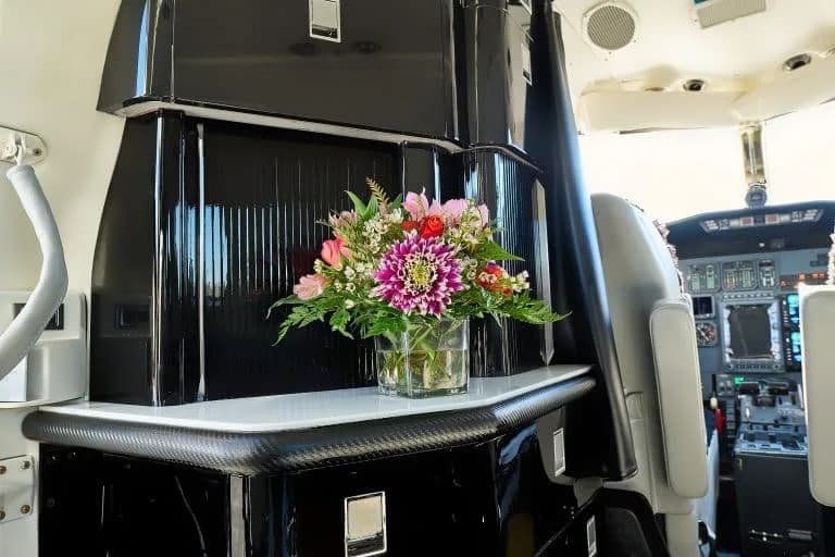 View of the aircraft interior with a flower arrangement and cockpit in the background.