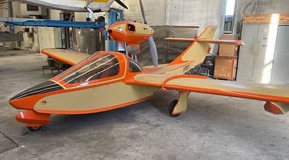 The I-PREY aircraft is shown in a hangar with an orange and cream paint scheme.