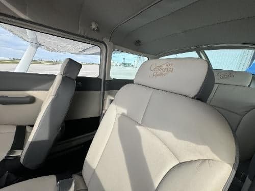 The interior of a Cessna 182 Skylane aircraft, showing the seats and headrests.