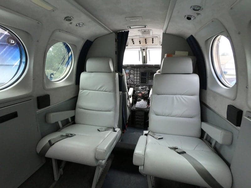 The interior of the Beechcraft King Air 90C, featuring comfortable seating and a view towards the cockpit.