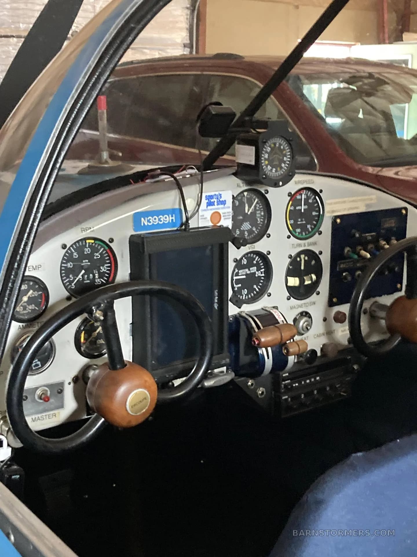 The cockpit of an Ercoupe aircraft showing the instrument panel, yokes, and engine controls.