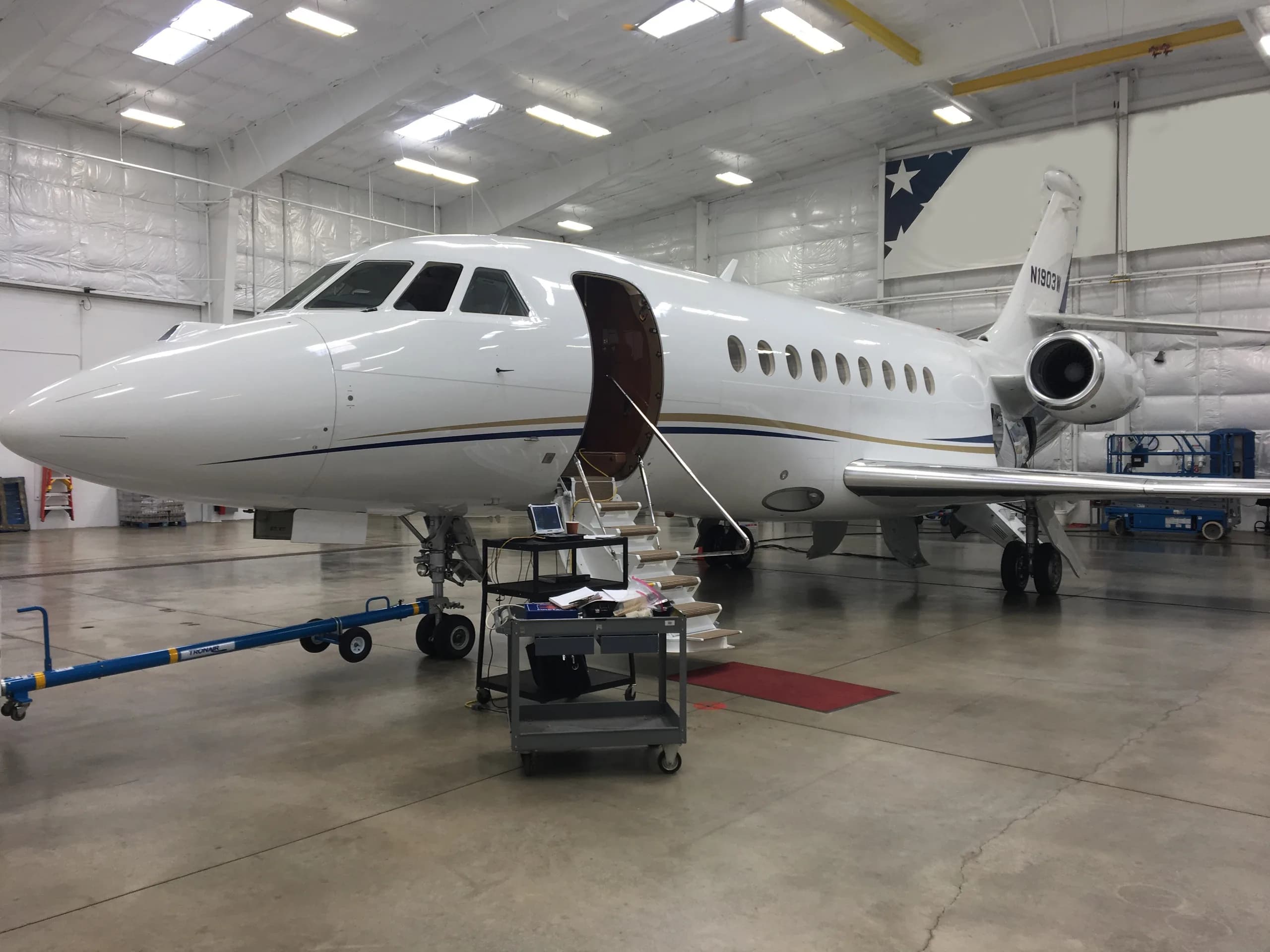 Falcon 2000EX EASy in a hangar with the door open.