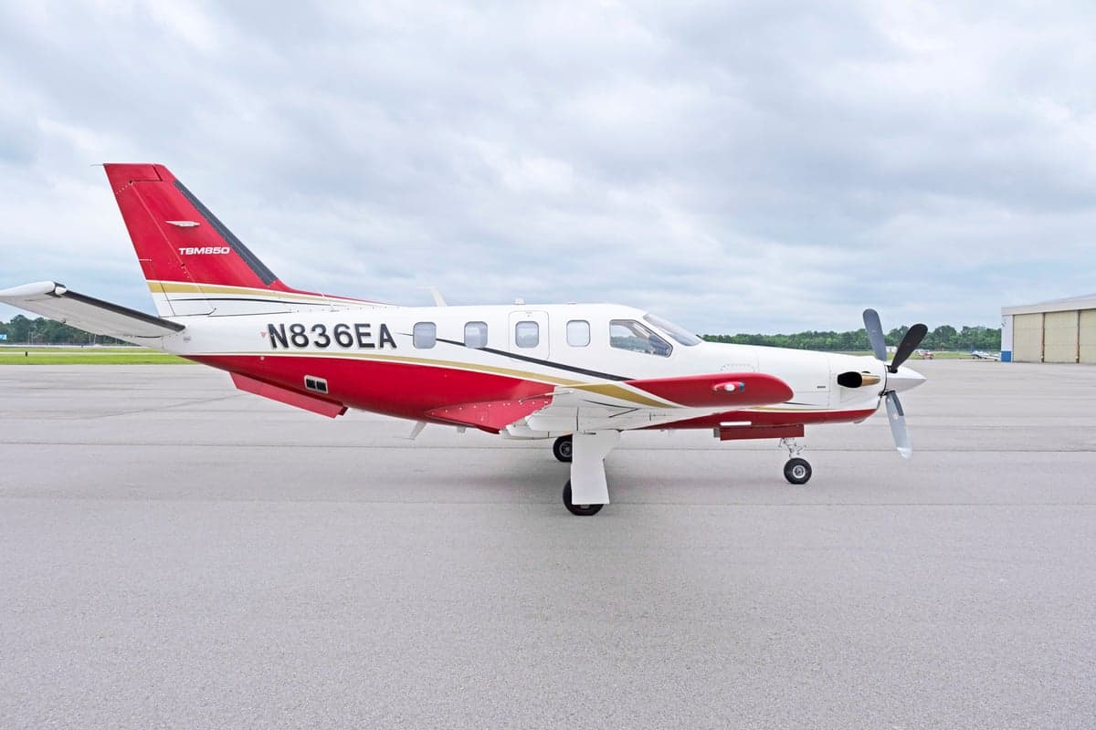 Side view of the TBM 850 aircraft N836EA on the tarmac.