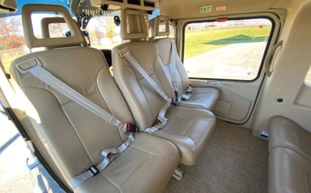 Interior view of the EC135 helicopter cabin with three seats.