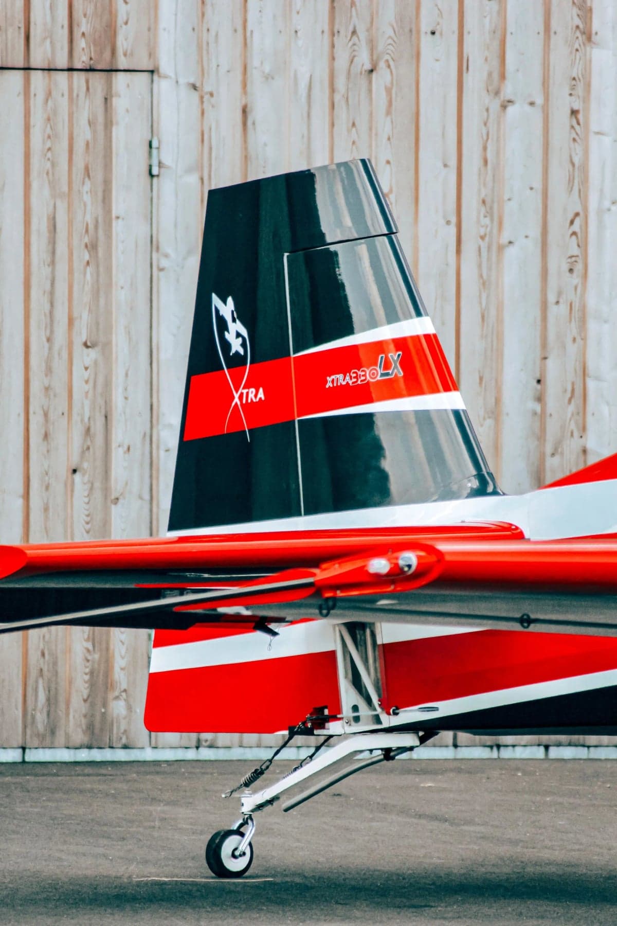 Side view of the nose of a red and white Extra EA-300LX.