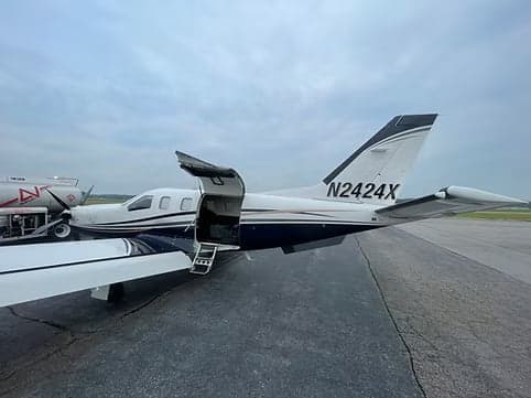Side view of a turboprop aircraft with registration N2424X being refueled.