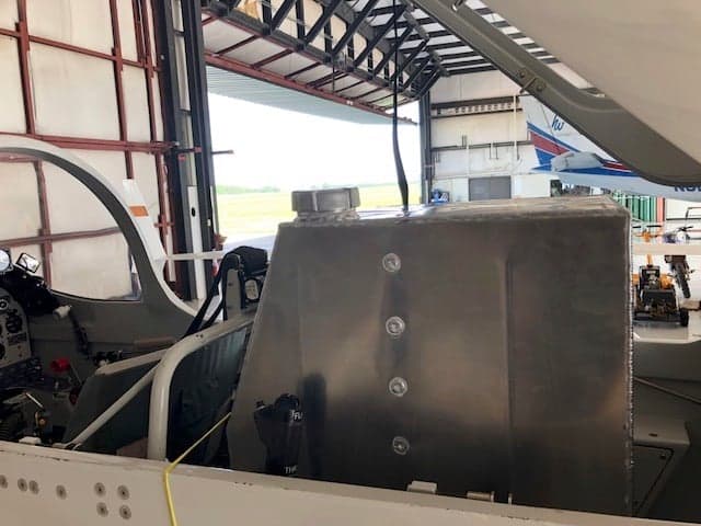 View of the aircraft's interior with a large metal box and part of the instrument panel.