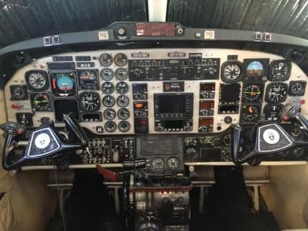 Wide view of the King Air aircraft cockpit instrument panel and yokes.