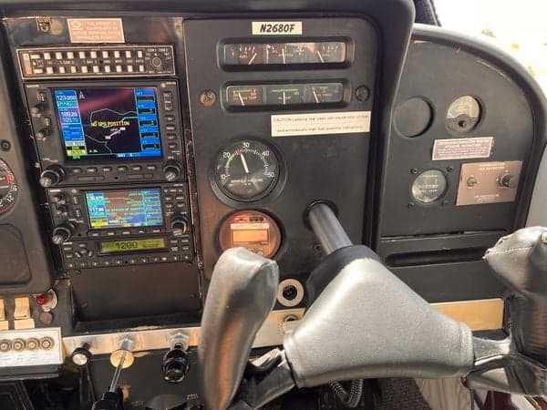 A close-up of the instrument panel in the cockpit of the aircraft N2680F, showing the GPS navigation system and engine gauges.