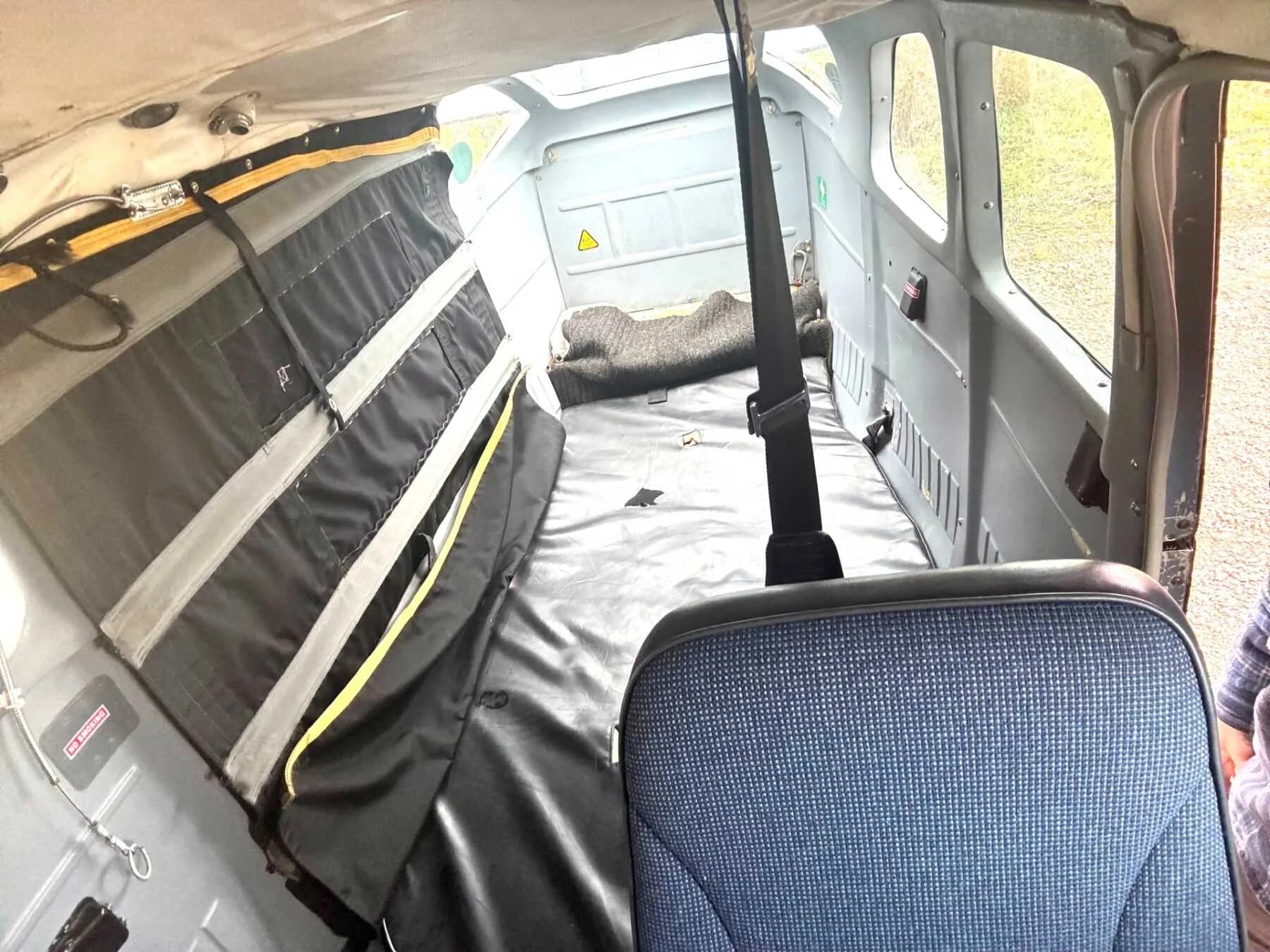 The interior of a Cessna 206 Stationair with a seat and cargo area.