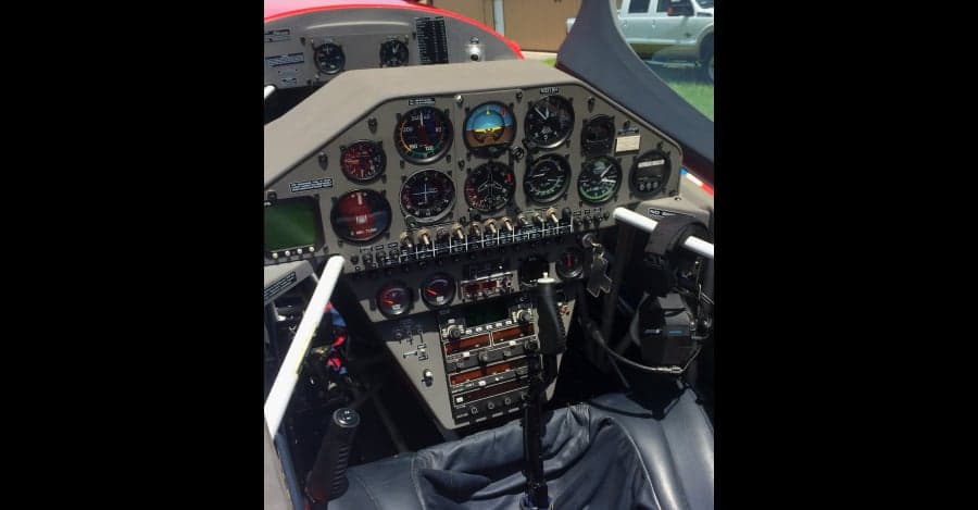 The cockpit of the aircraft features a gray instrument panel with various gauges and controls.
