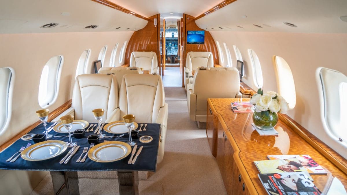 Interior view of the jet's cabin with seating and tables.