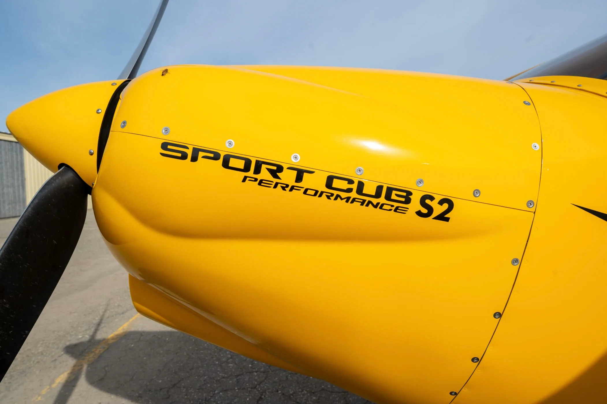 A close-up of the yellow fuselage displaying "SPORT CUB S2 PERFORMANCE" text.
