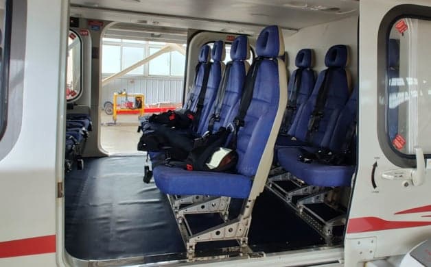 Helicopter cockpit with instrument panel and controls.