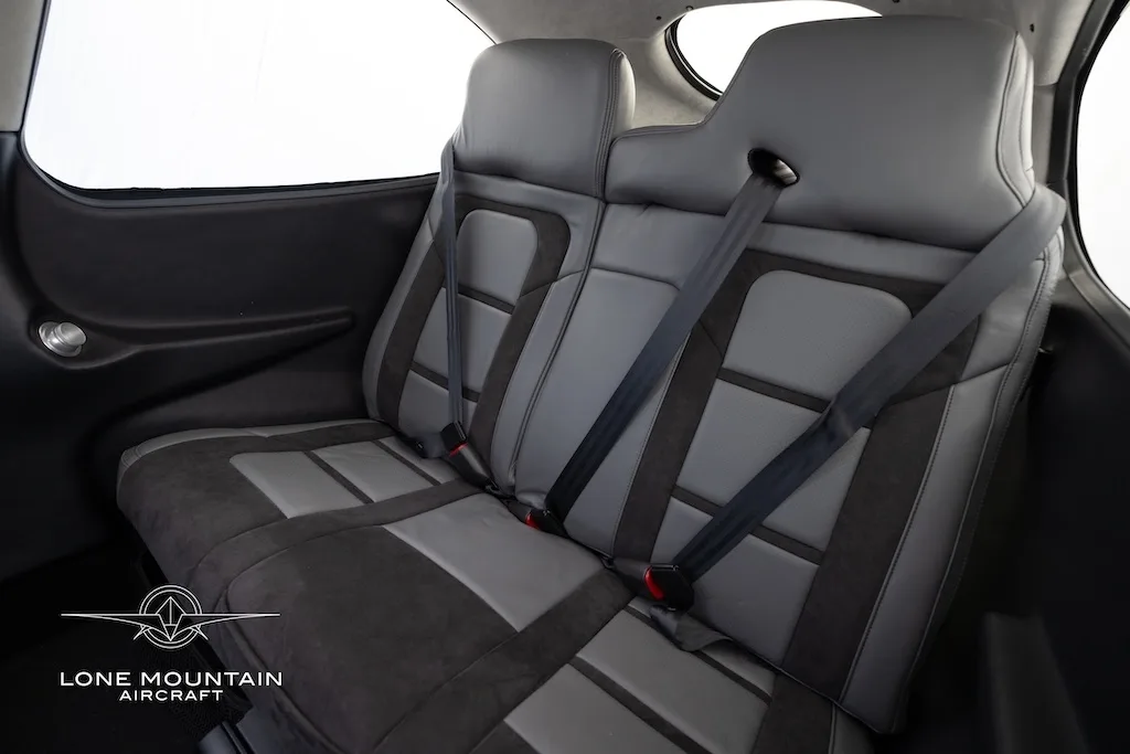 A close-up view of the grey and black rear passenger seats of the aircraft cabin.