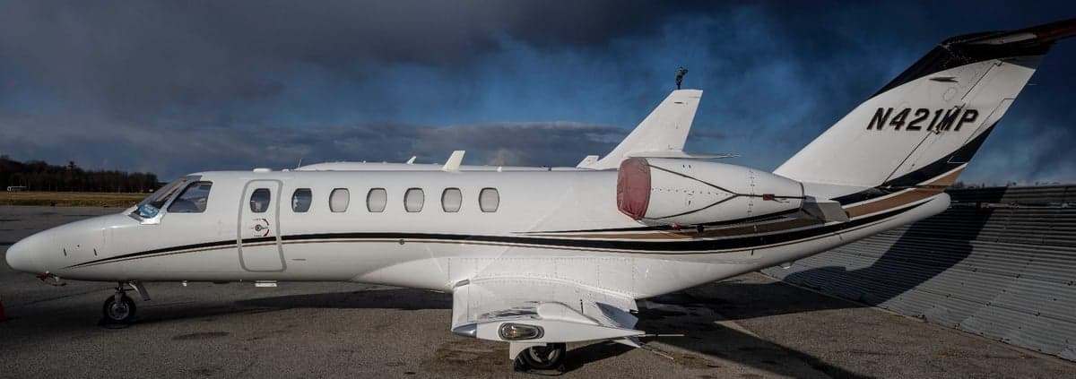 Side view of a white and brown Citation CJ3, registration N421MP.