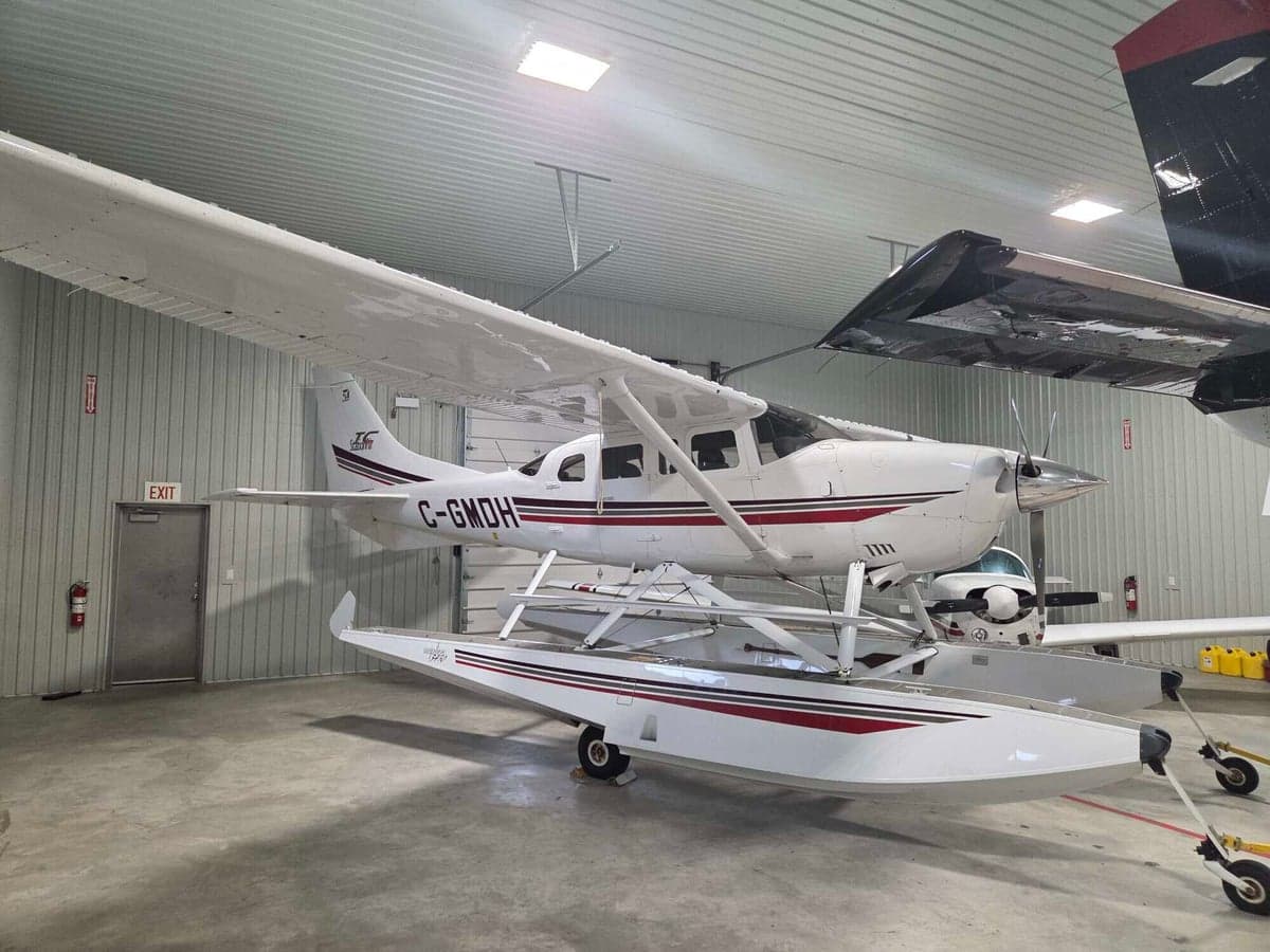 Side view of a Cessna Caravan floatplane in a hangar.