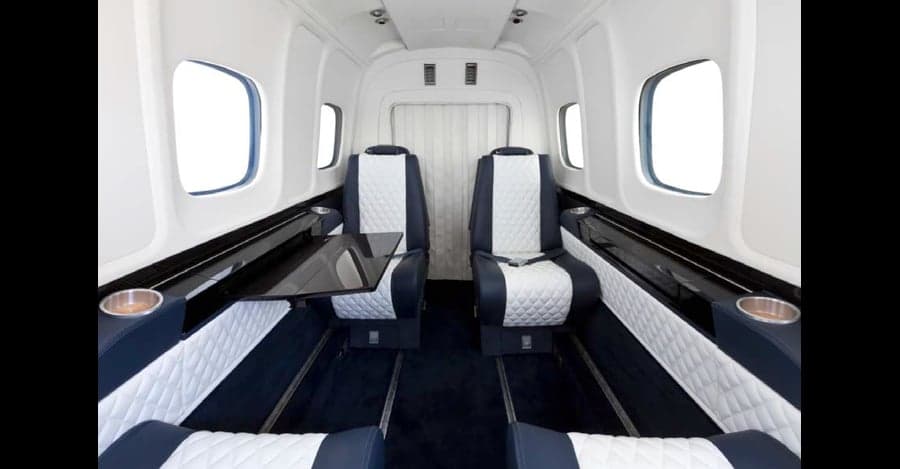 Aircraft cabin interior with blue and white seats.