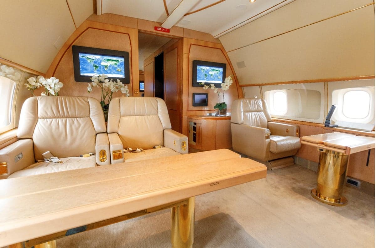 Aircraft interior with leather seats and a table.