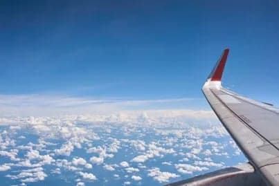 View of the wing of an aircraft flying above the clouds.