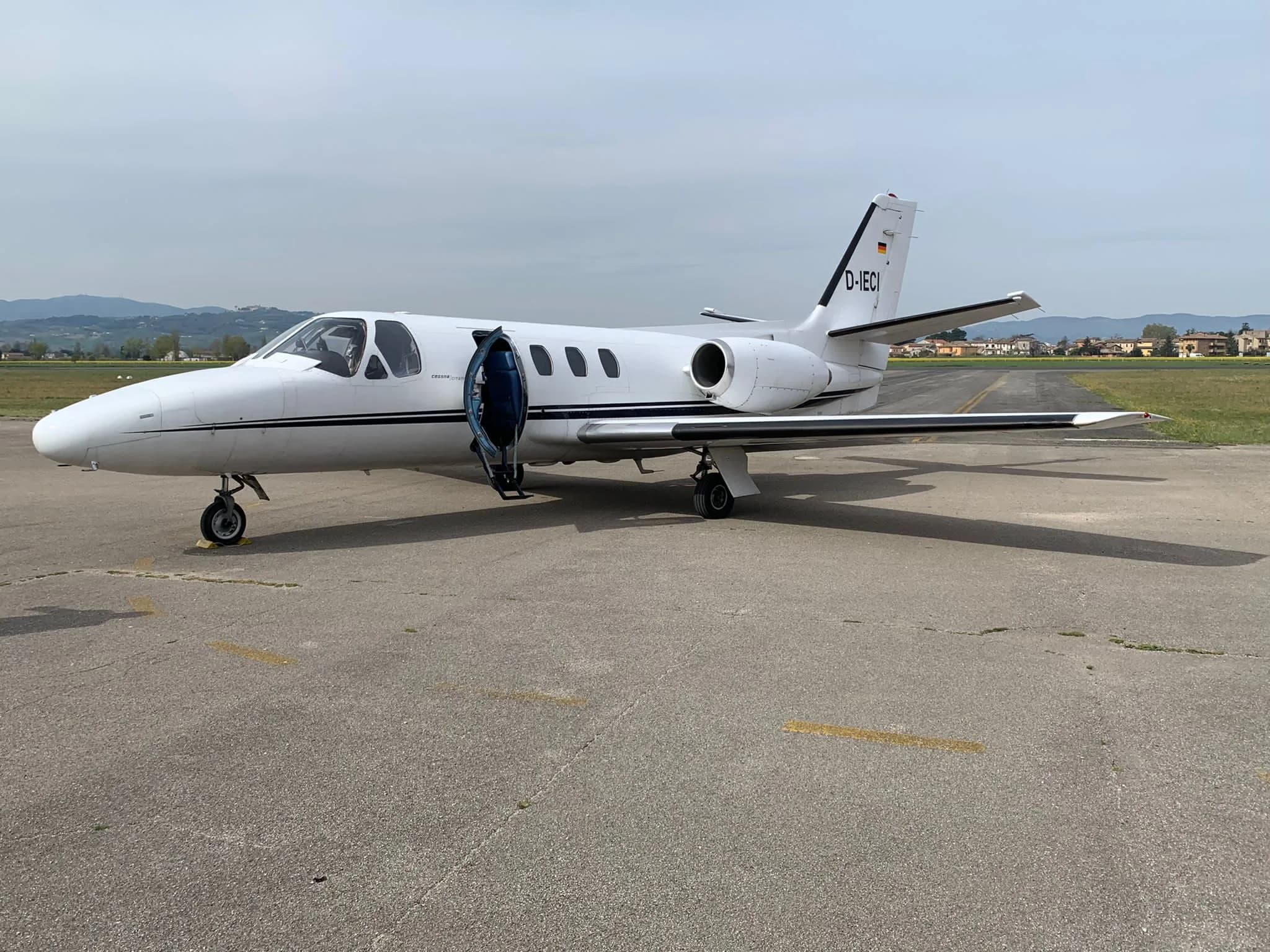 A Cessna Citation Mustang aircraft, registration D-IECI, parked on the tarmac with the door open.