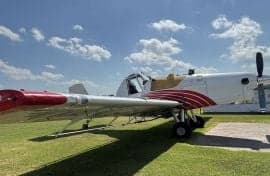 An Air Tractor crop duster sits on the grass.
