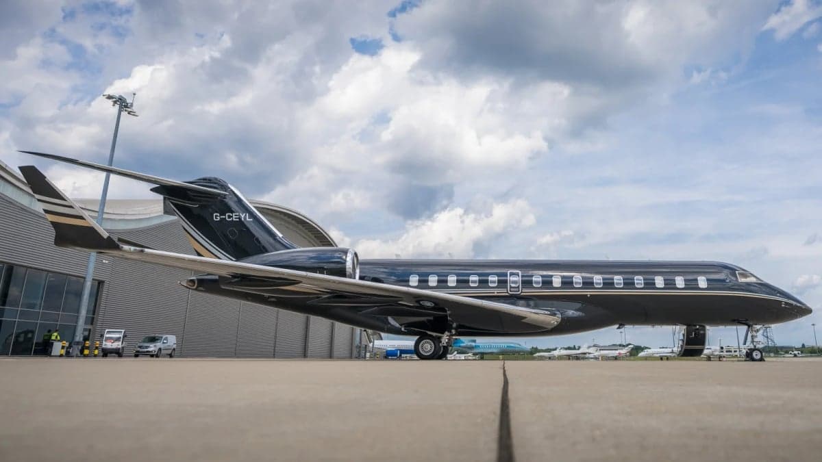 Side view of a black and silver jet parked on the tarmac.