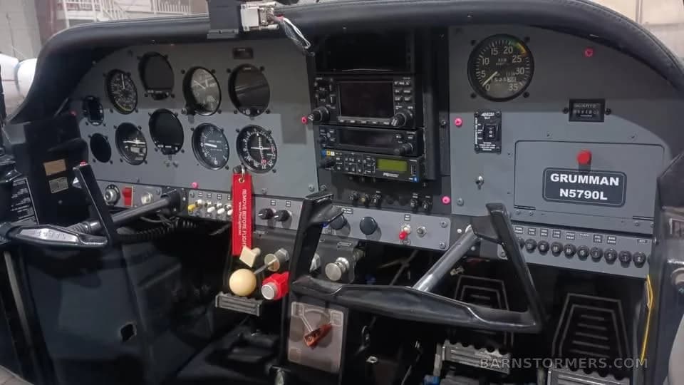The cockpit of a Grumman aircraft, showing the instrument panel and controls.