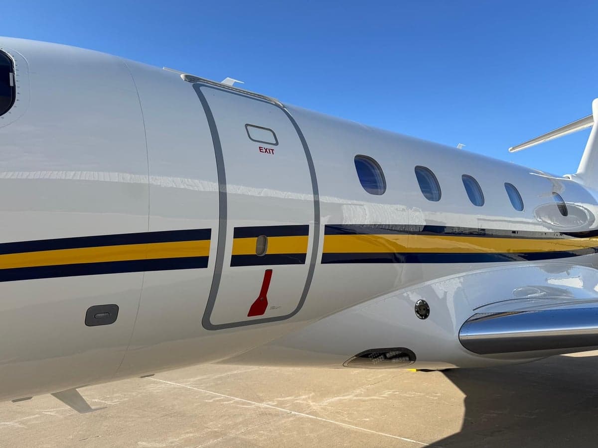 Close up of the side of the aircraft, showing the exit door and windows.