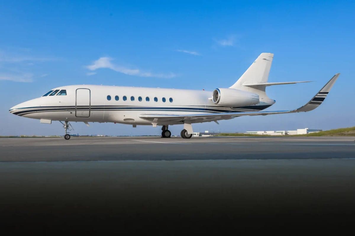 A white and black jet aircraft on the tarmac.