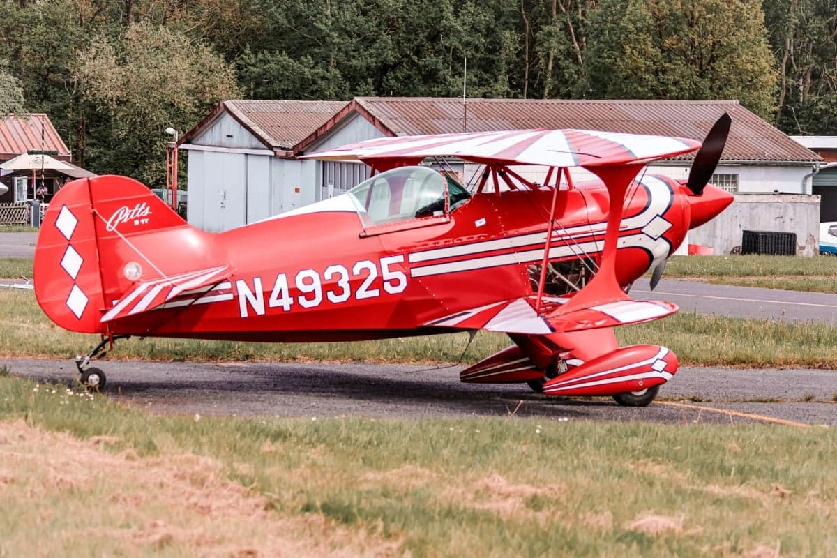 A red and white Pitts S-1T biplane with registration N49325 viewed from the front.