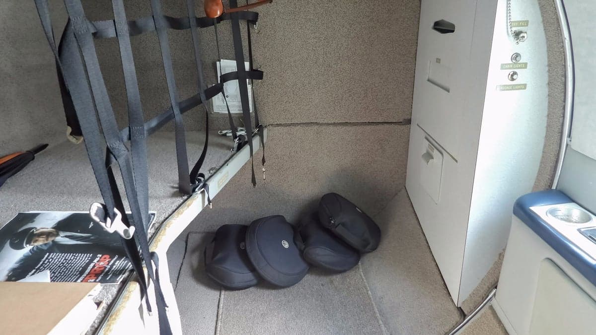 The carpeted rear cabin area of the aircraft, showing cargo netting and storage compartments.