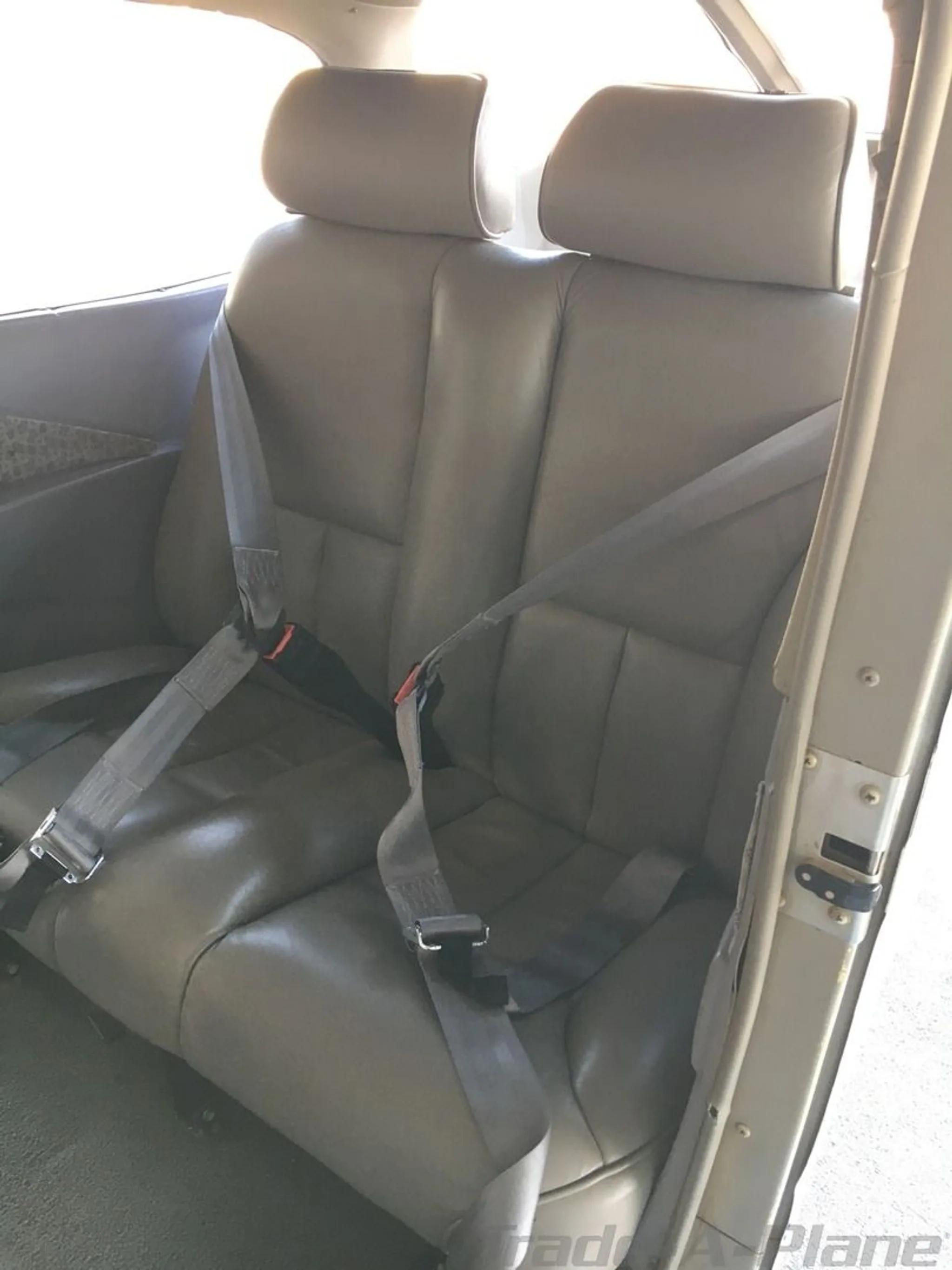 The two rear grey leather seats with seatbelts in the cabin of a Cessna 172SP Skyhawk.