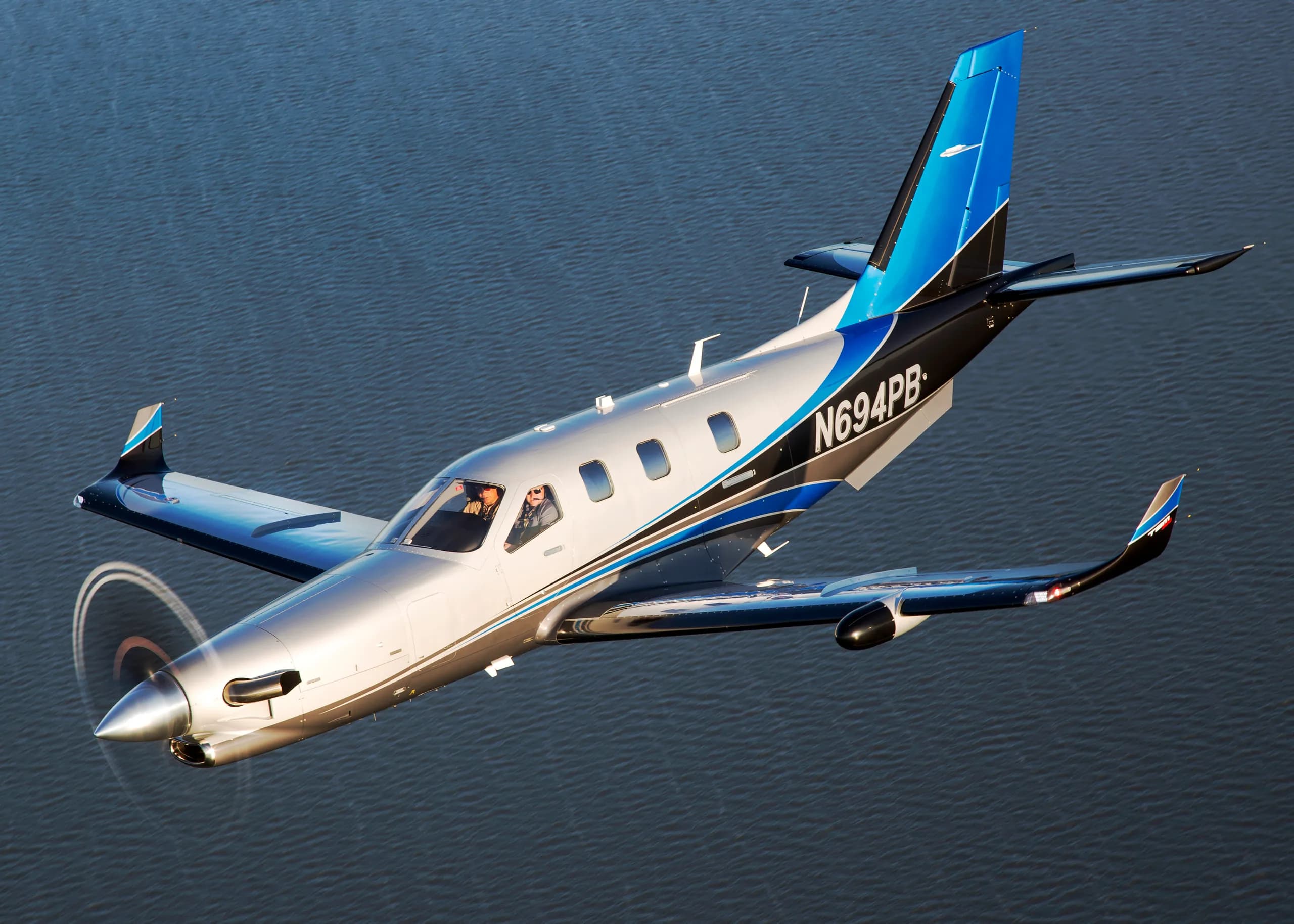 Turboprop aircraft in flight over water.