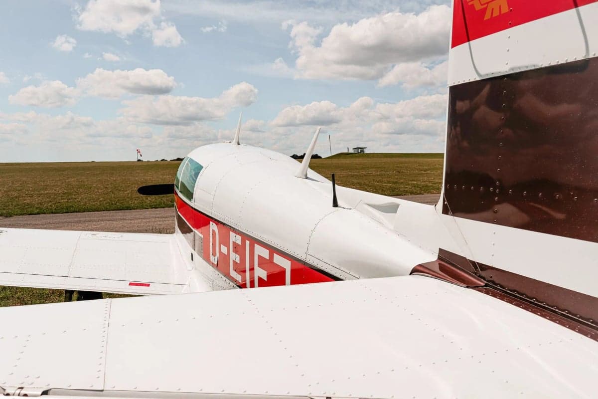 Mooney M20J aircraft D-EIFJ parked near a hangar.