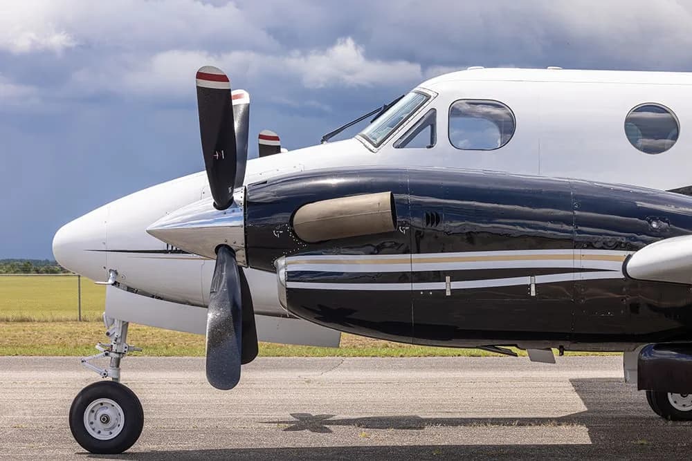 Close-up of the nose and propeller of a King Air aircraft with registration N216RP.