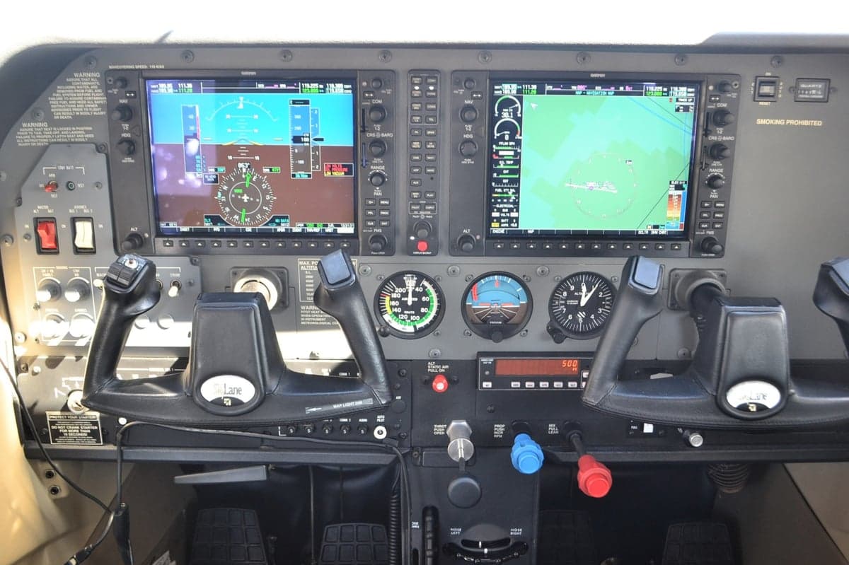 Close up of the aircraft's instrument panel with dual screens and flight controls.