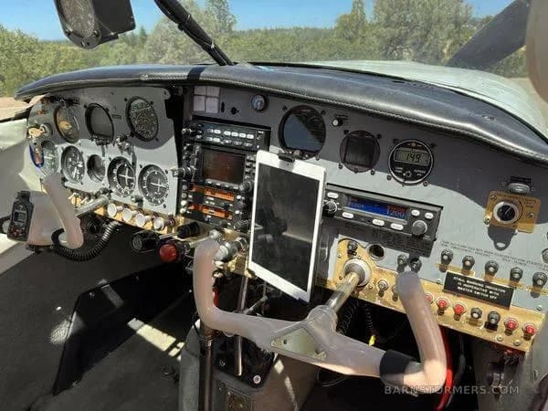 The cockpit of a small aircraft shows the instrument panel, yokes, and an iPad mounted in the center.