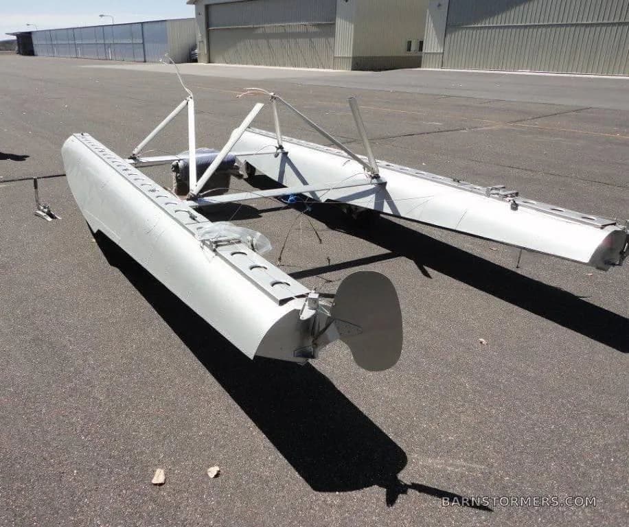 A float positioned on the ground near a hangar.