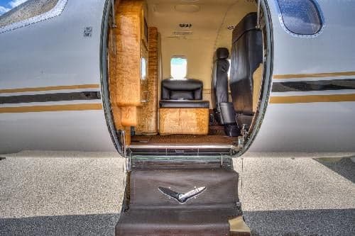 The Learjet 31A cabin is visible through the open door and airstair.