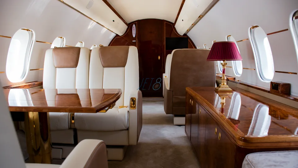 Aircraft interior with leather seats and wood accents.