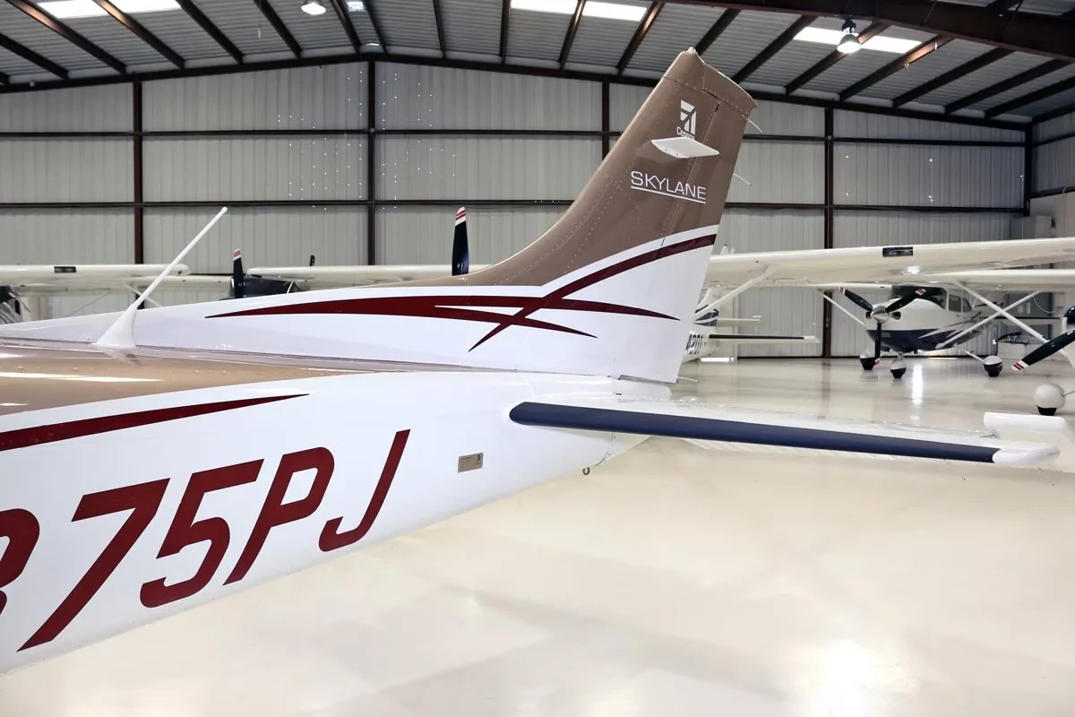 A close-up of the tail section of the brown and white Cessna Skylane N875PJ, showing the registration and "Skylane" logo.