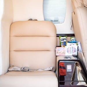 Interior of a Cessna Citation CJ1+ with a seat and snacks.