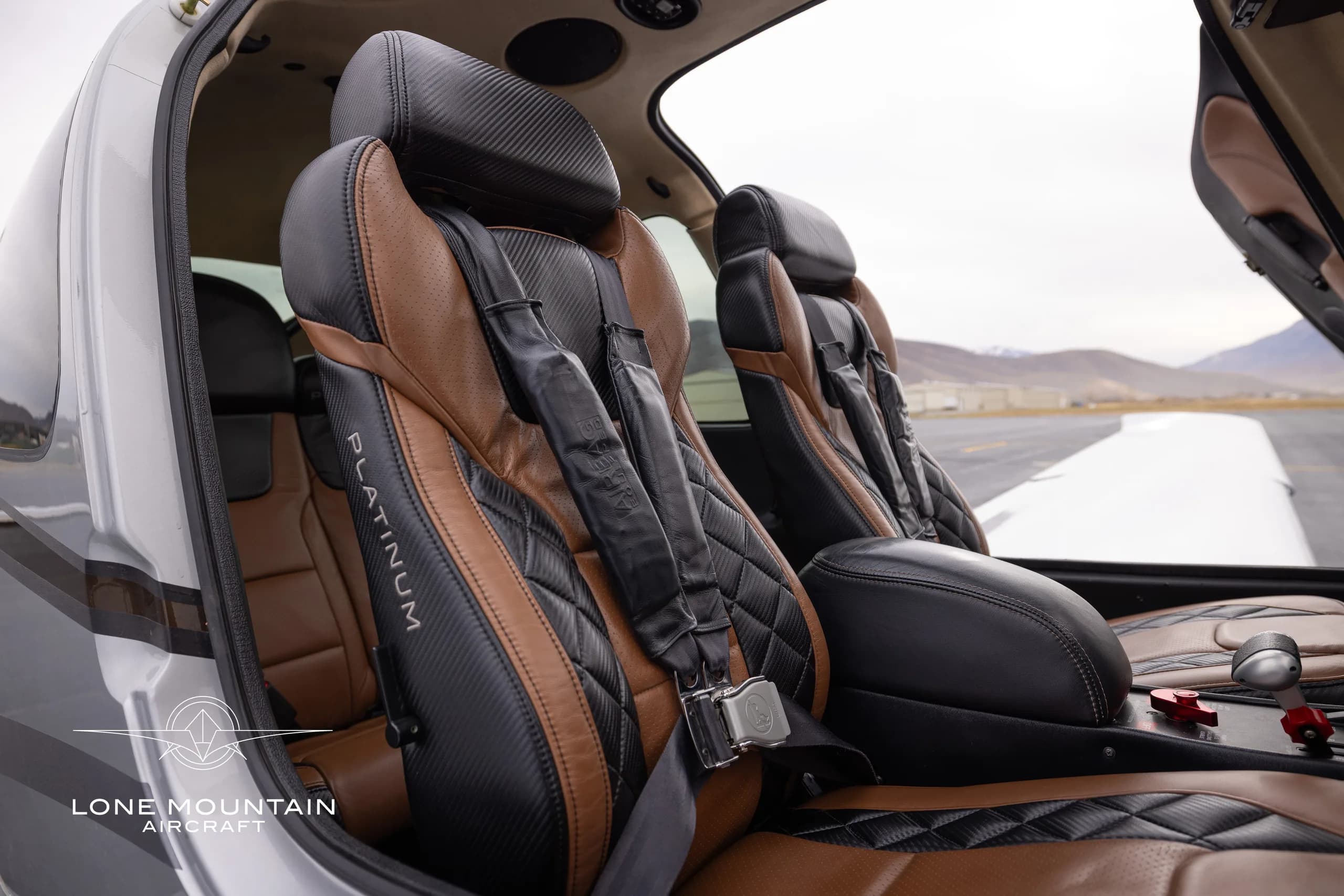 The interior of a Cirrus SR22T aircraft with brown and black leather seats and a Platinum Edition logo.