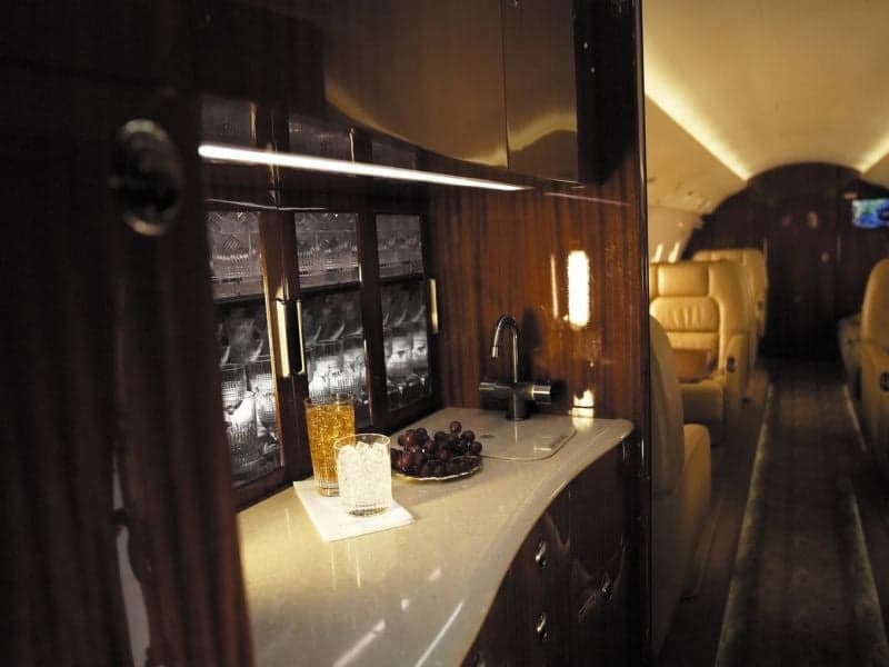 A view of the aircraft's interior, showing a seat and a table with a laptop on it.