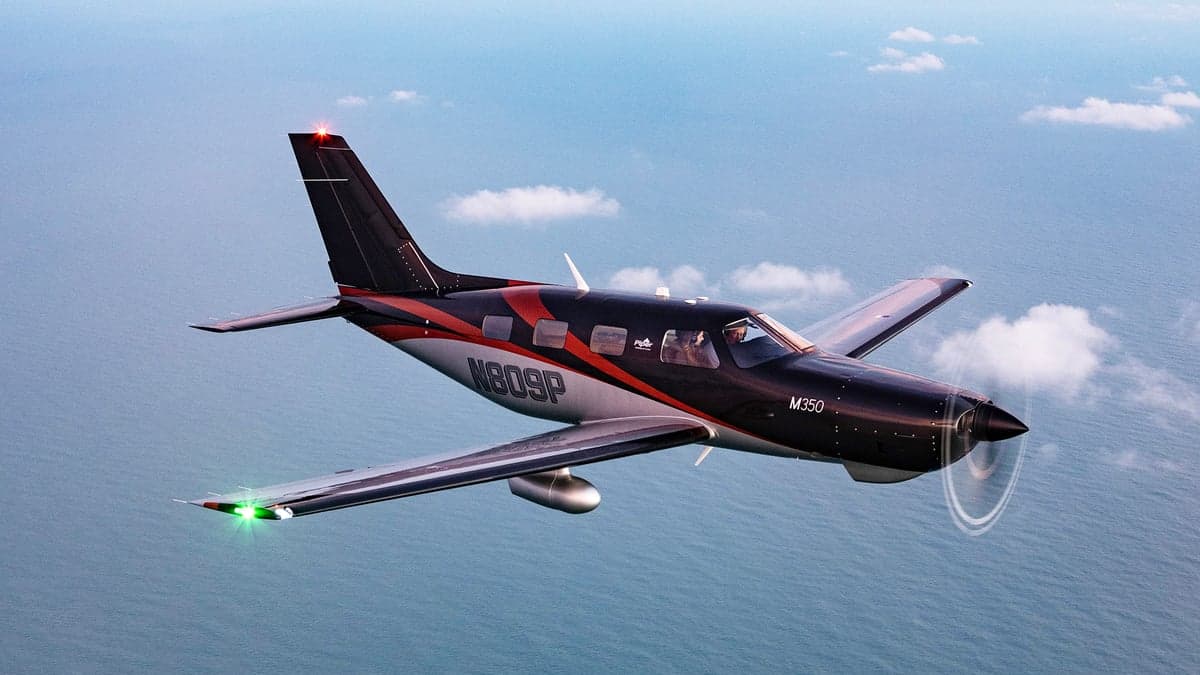 Piper M350 in flight over water with registration N809P.