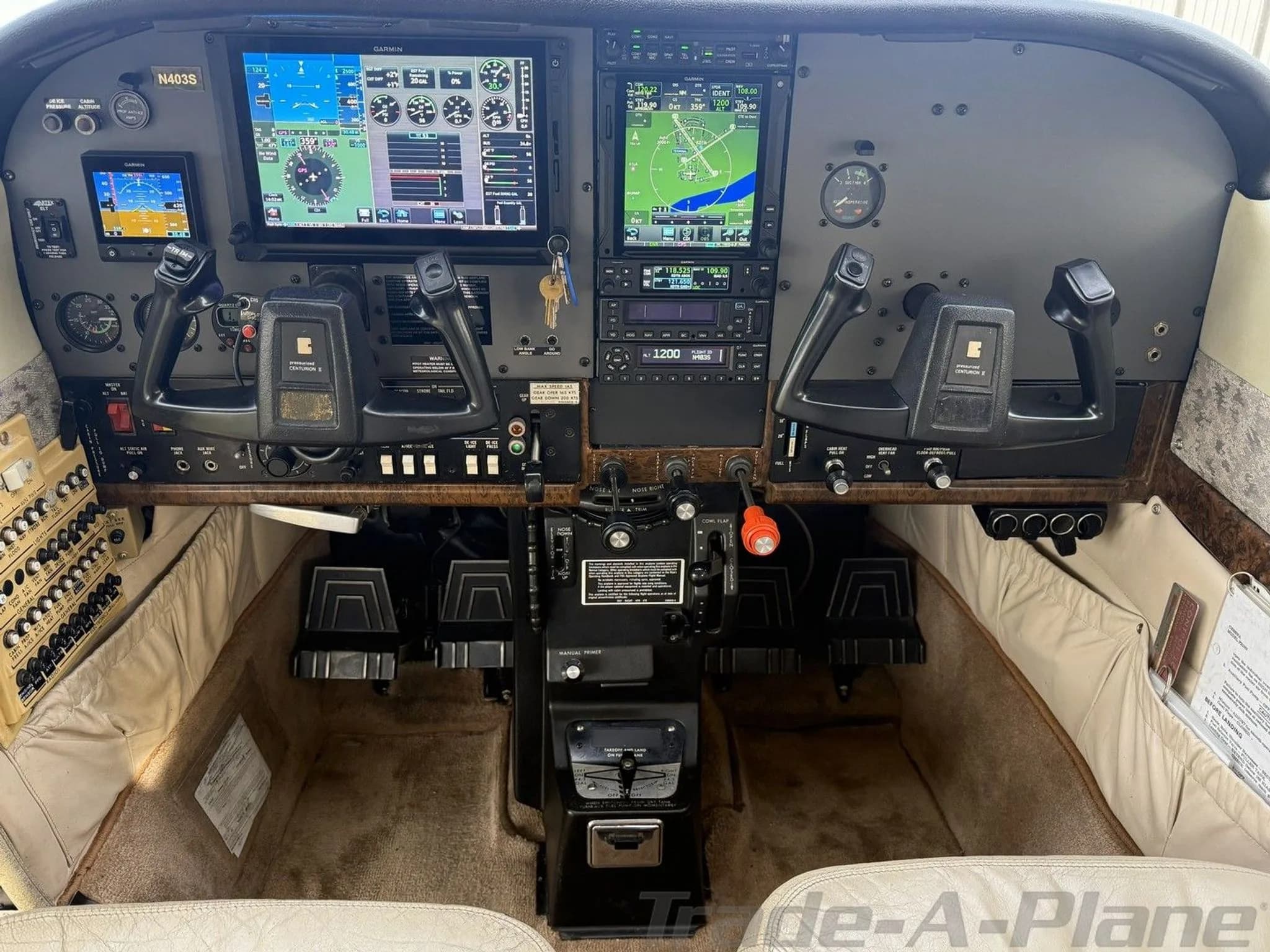 The cockpit of the Cessna 210 Centurion aircraft (N403S) with dual Garmin G1000 displays and a beige interior.