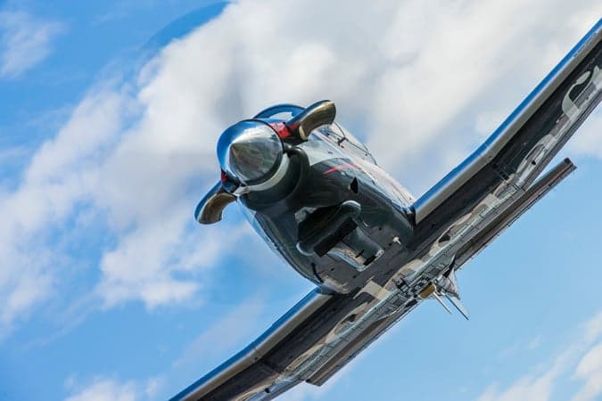 Close-up view of the front of a Beechcraft T-6C Texan II aircraft in flight.