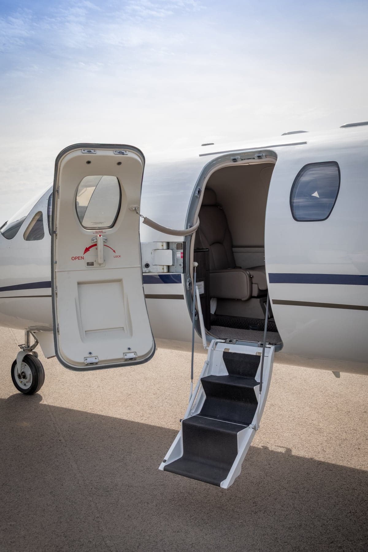 The open door and airstair of a Citation CJ3 aircraft reveal a glimpse of the interior.